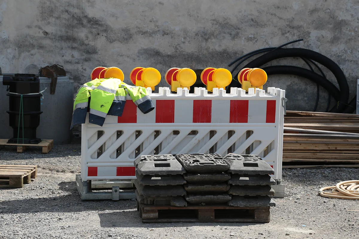 Eures • Baustelle mit Absperrung, Warnleuchten und reflektierender Arbeitskleidung.