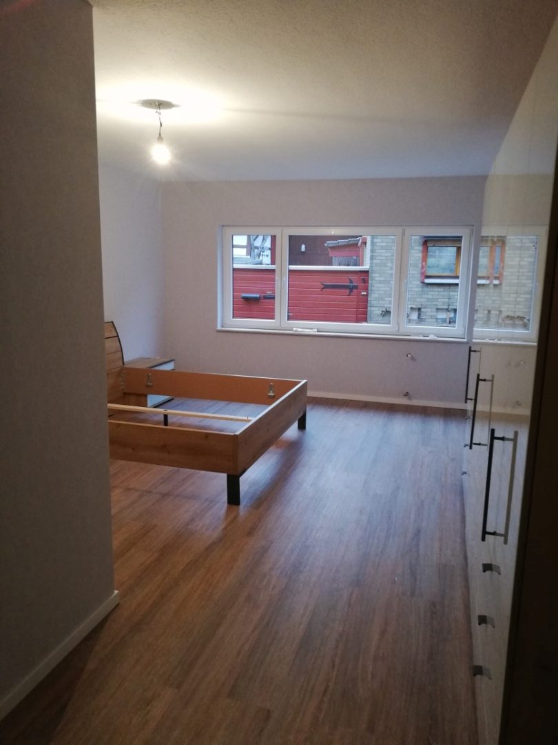 Eures • Helle, minimalistische Wohnung mit Holzfußboden und Bettgestell.