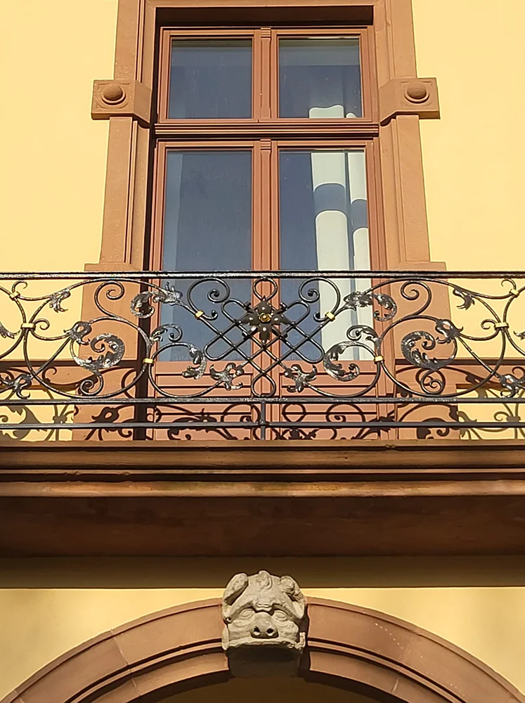 Eures • Historisches Fenster mit kunstvollem Balkon und Skulptur.