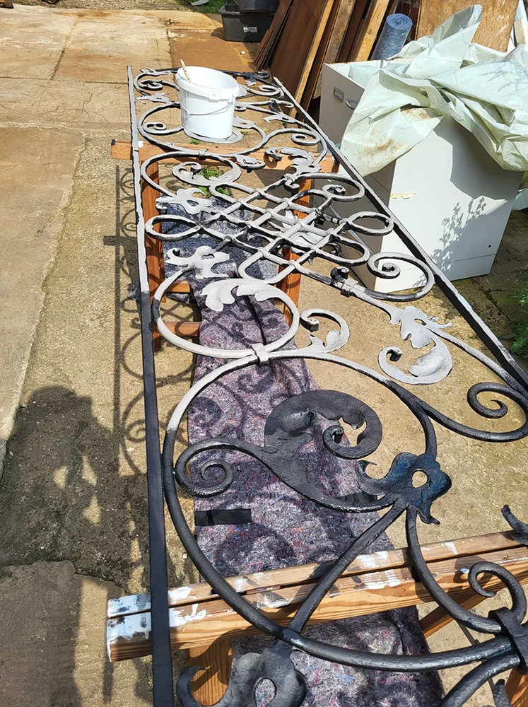 Eures • Eisenzaun mit filigranen Ornamenten in der Werkstatt.