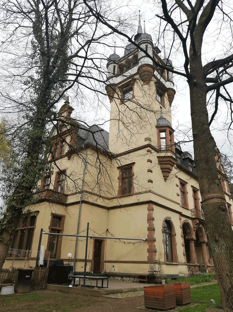 Eures • Historisches Gebäude mit Turm und verwitterter Fassade.