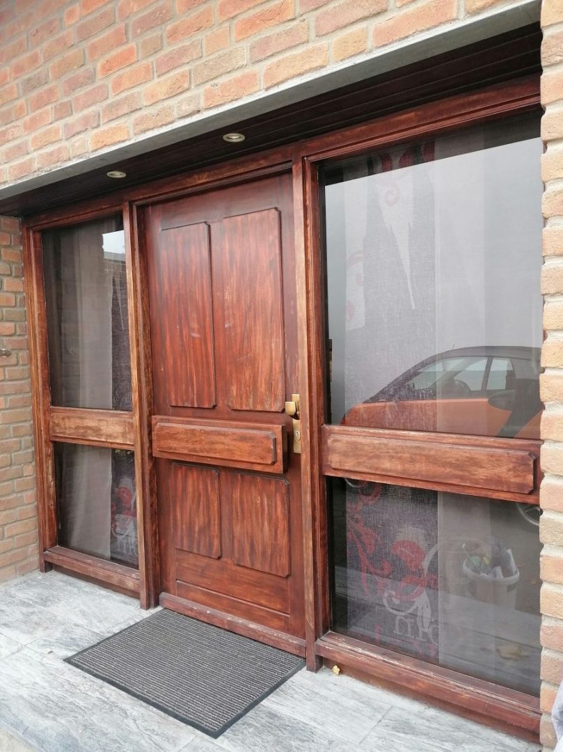 Eures • Holztür mit Glaselementen und Fußmatte, modernes Design.