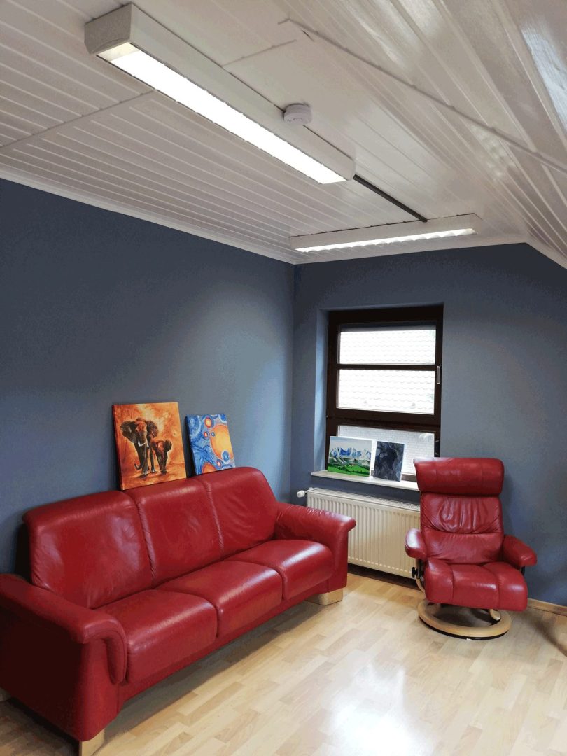 Eures • Rotes Sofa und Drehstuhl in moderner, blauer Wohnzimmerumgebung.