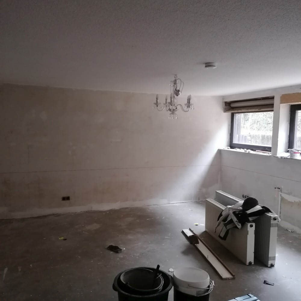 Eures • Ungestalteter Raum mit dekorativem Kronleuchter und Fenstern.