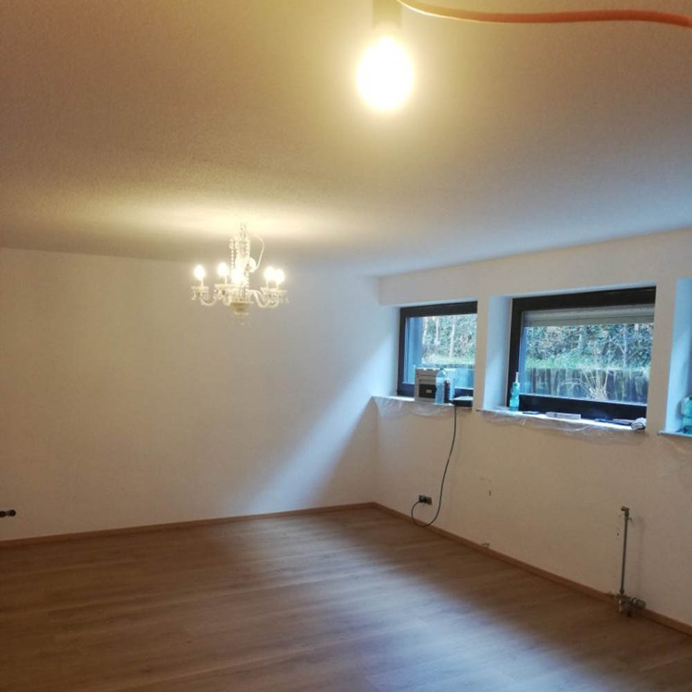 Eures • Helles Zimmer mit Kronleuchter und großen Fenstern.