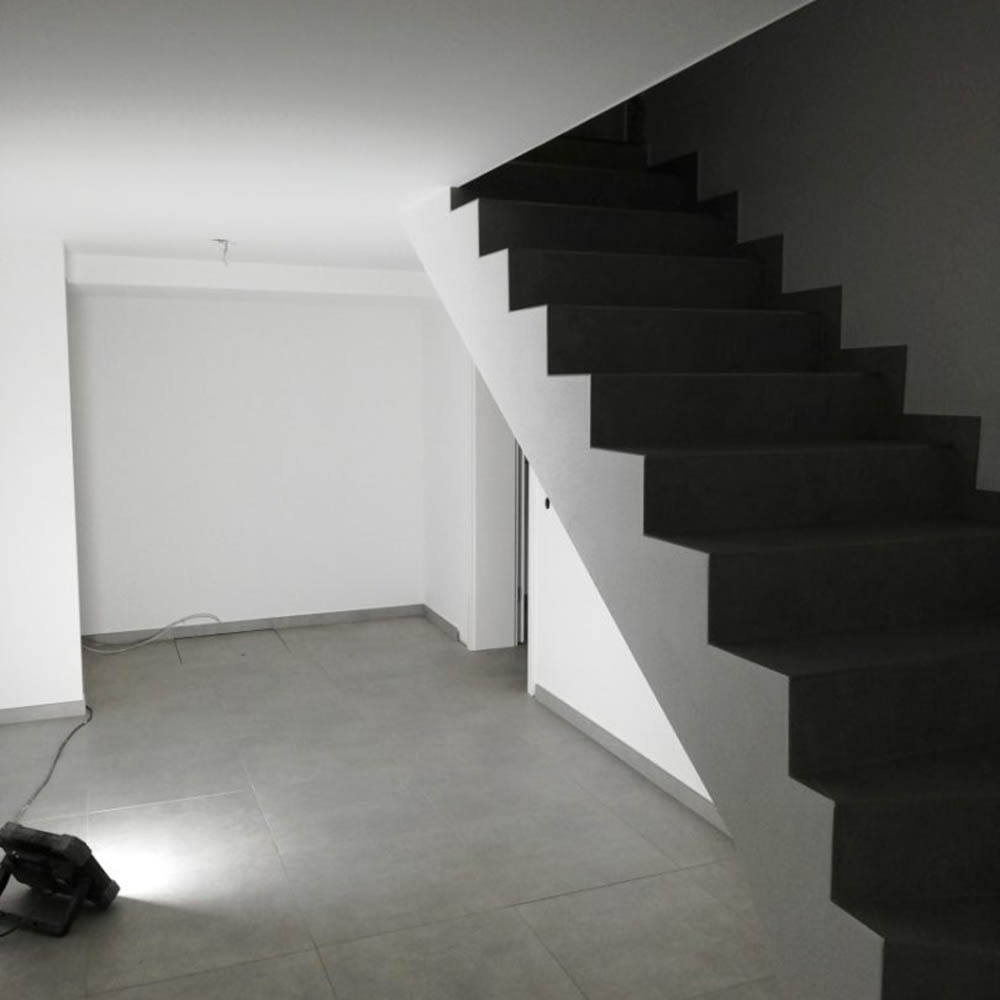 Eures • Moderne Treppe in minimalistischen Innenraum mit Fliesenboden.