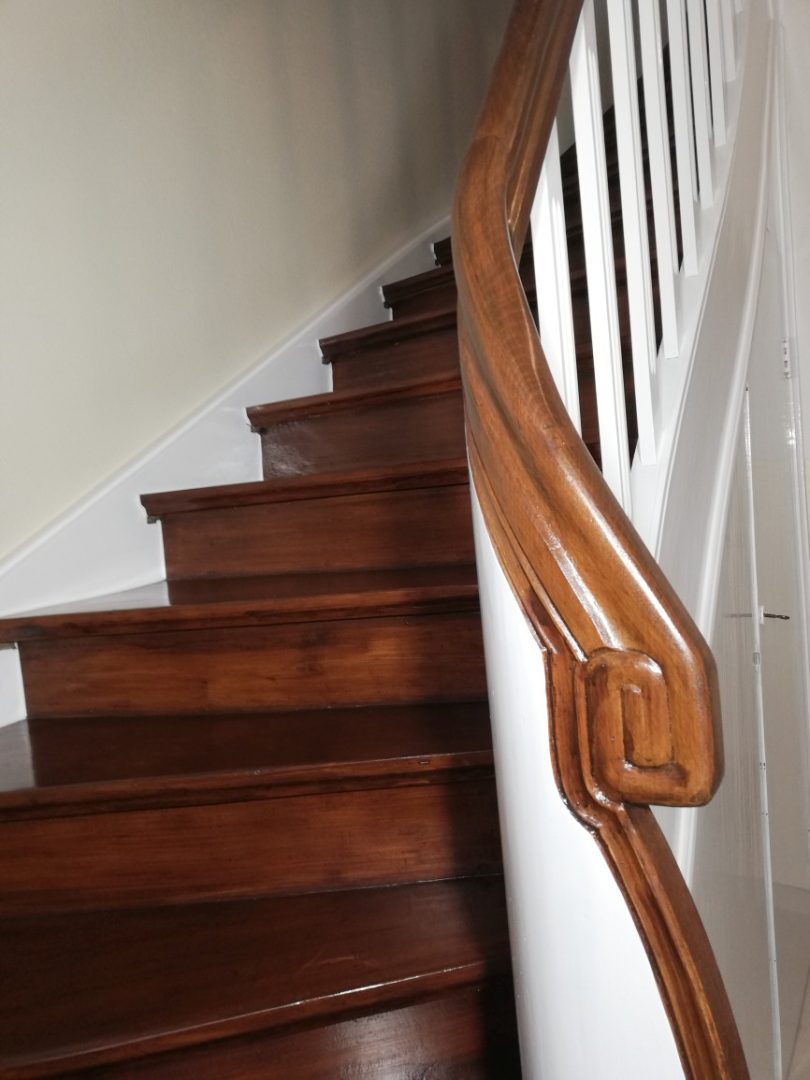 Eures • Holztreppe mit kunstvollem Geländer, helles Treppenhaus.